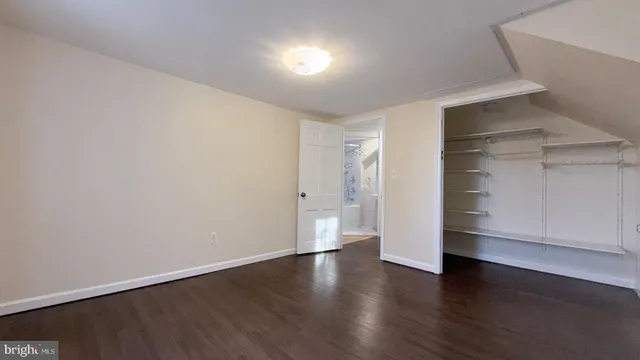 a view of an empty room with a closet and wooden floor