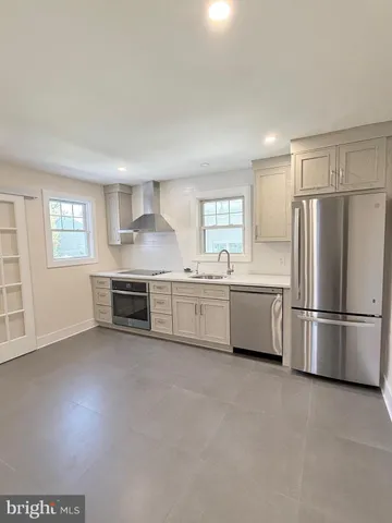 a kitchen with stainless steel appliances a refrigerator sink and cabinets