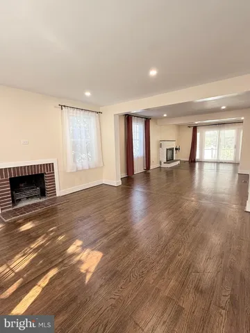a view of empty room with wooden floor and fireplace