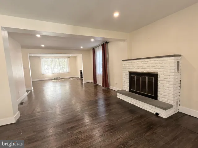 an empty room with wooden floor and fireplace