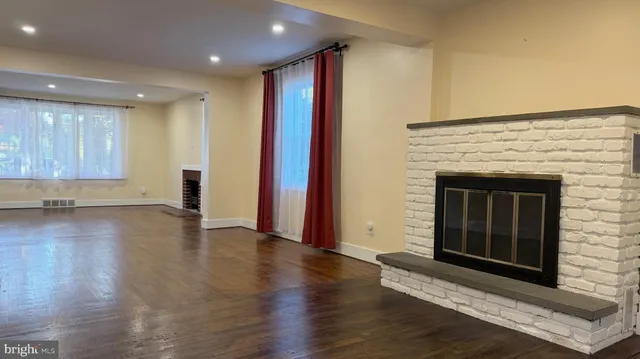 a view of a hallway with wooden floor and a fireplace