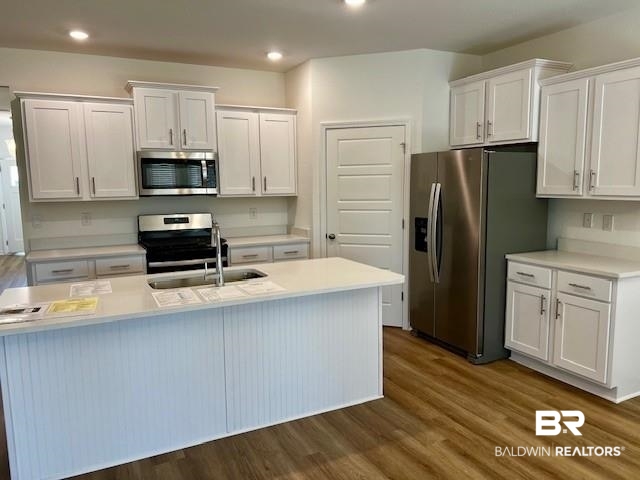 13822 Antler Hl Road Daphne, AL 36527 - Photo 3 of 39 Kitchen with white cabinets, stainless steel appliances, an island with sink, and dark hardwood / wood-style flooring
