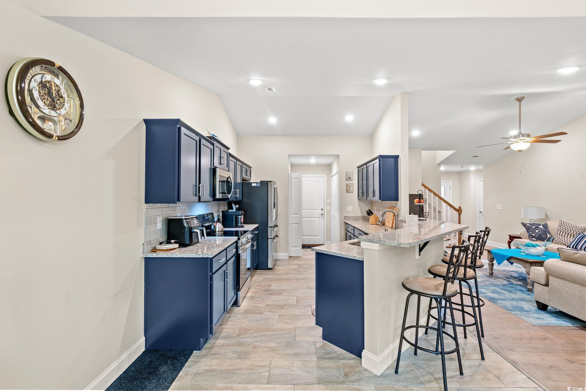 1209 Wehler Court Conway, SC 29526 - Photo 11 of 32 Kitchen with tasteful backsplash, blue cabinetry, a breakfast bar, light stone countertops, and a peninsula