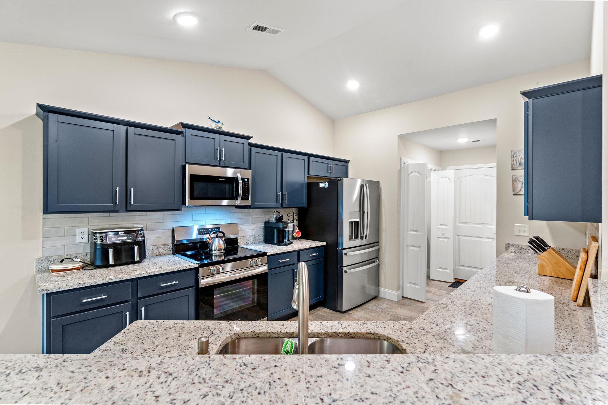 1209 Wehler Court Conway, SC 29526 - Photo 9 of 32 Kitchen with stainless steel appliances, light stone counters, vaulted ceiling, decorative backsplash, and recessed lighting