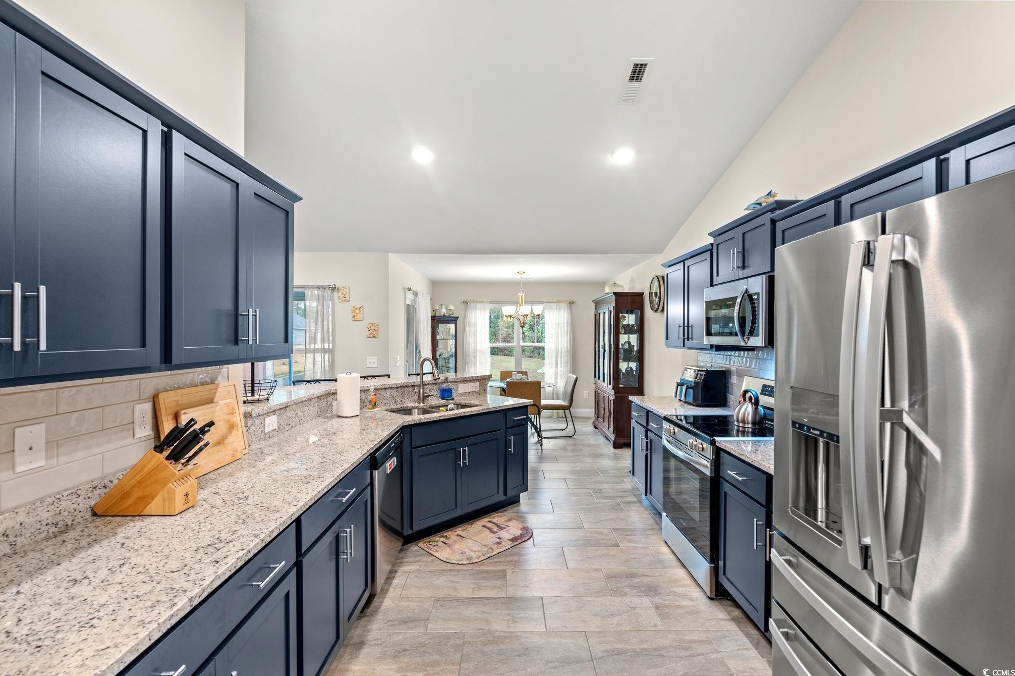 1209 Wehler Court Conway, SC 29526 - Photo 10 of 32 Kitchen featuring appliances with stainless steel finishes, light stone countertops, a chandelier, decorative light fixtures, and blue cabinetry