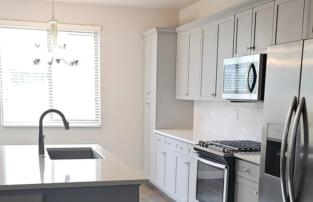 a kitchen with stainless steel appliances granite countertop a refrigerator and a sink