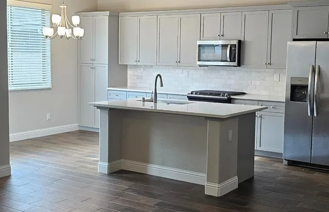 a kitchen with stainless steel appliances granite countertop a sink a stove a microwave and cabinets