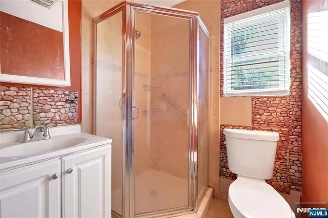 a bathroom with a sink a toilet and shower