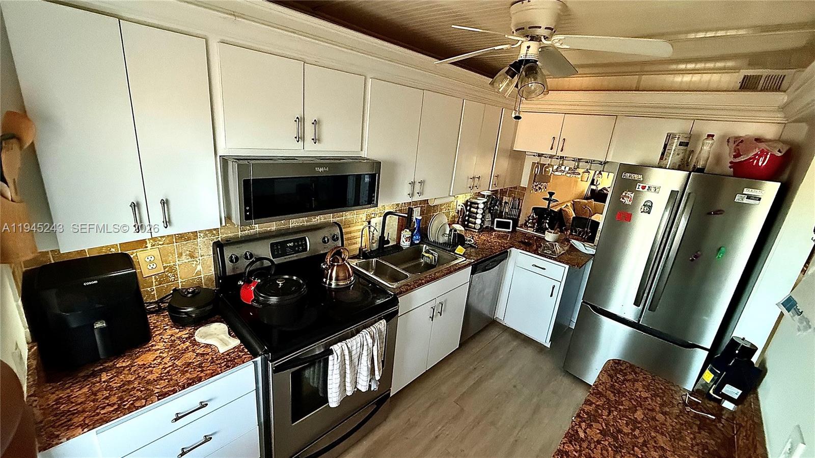 a kitchen with stainless steel appliances granite countertop a stove a sink and a refrigerator
