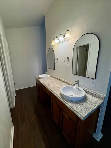 a bathroom with a granite countertop sink a toilet and a mirror