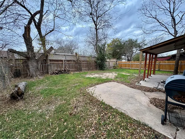 a view of a backyard with table and chairs and a large tree
