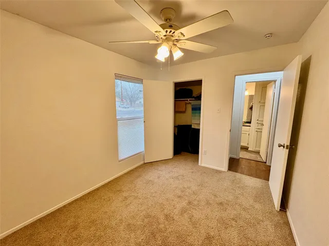 an empty room with fan and entrance