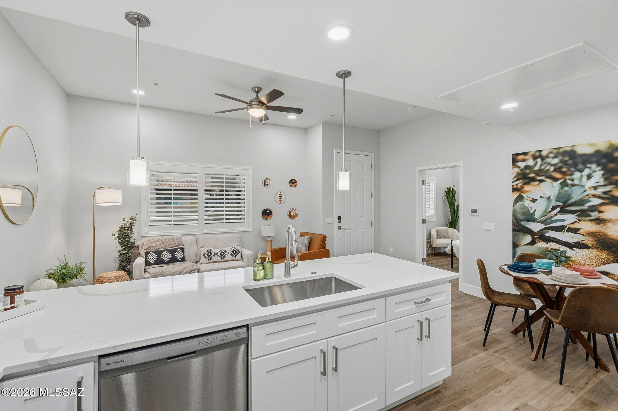 2020 East River Road, Unit 201 Tucson, AZ 85718 - Photo 4 of 10 a kitchen with a sink dishwasher a dining table and chairs with wooden floor