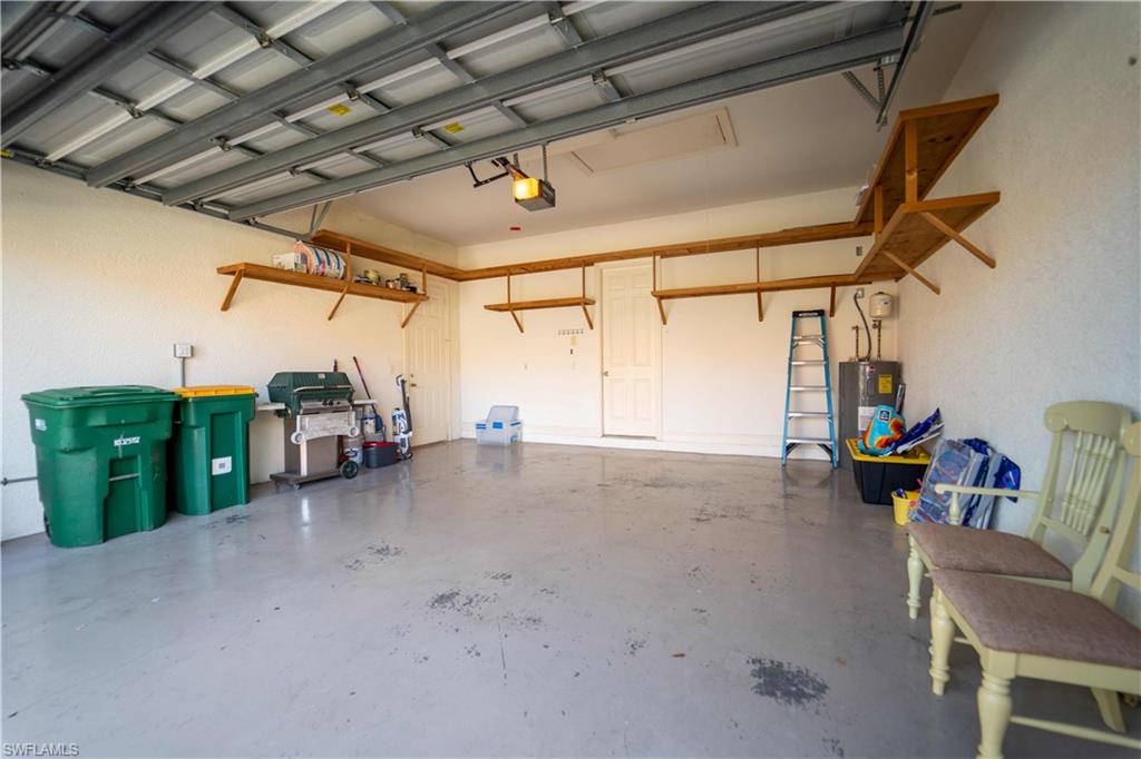 5886 Paradise Circle Naples, FL 34110 - Photo 16 of 19 Garage featuring a garage door opener and water heater