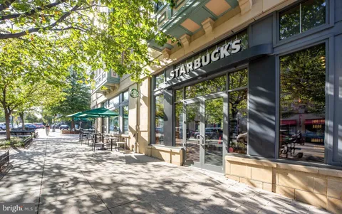 a view of a building with a tree in front of retail shops