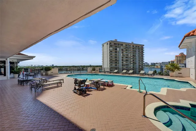 a view of a swimming pool and lounge chairs in back yard of the house