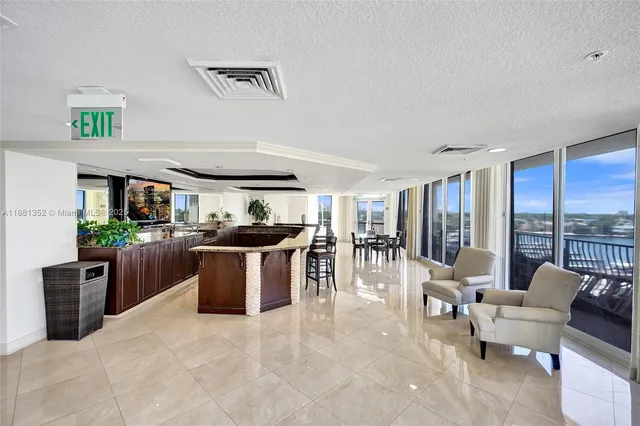 a kitchen with stainless steel appliances kitchen island granite countertop a table chairs sink and cabinets