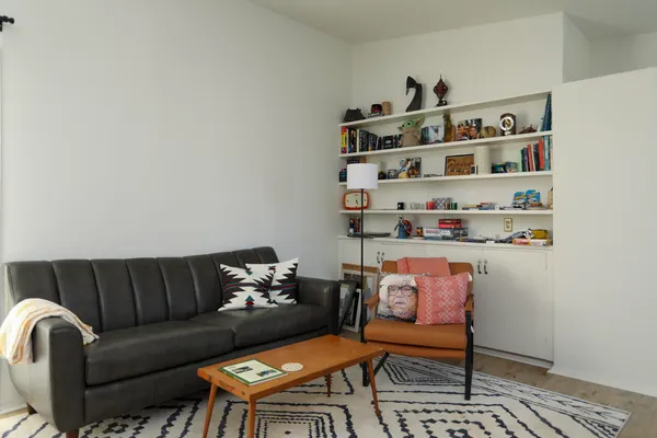 a living room with furniture and a shelf