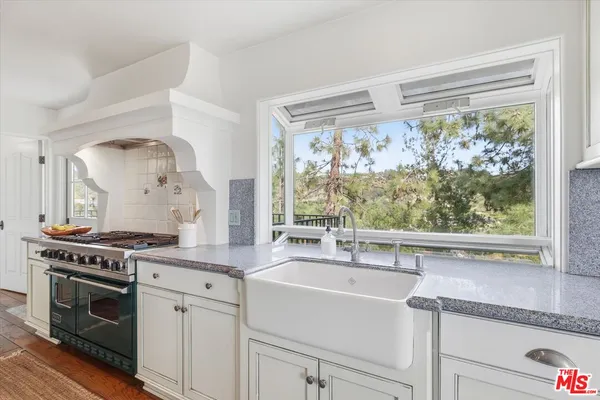 a kitchen with a stove a sink and a window