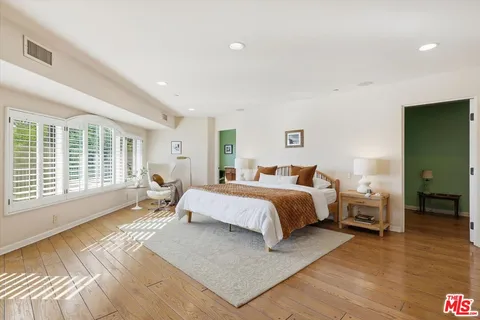 a spacious bedroom with a large bed a walk in closet and a couch