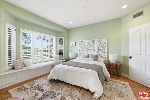 a bedroom with a bed and a large window