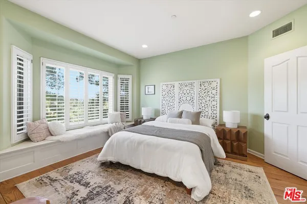 a spacious bedroom with a bed and glass window