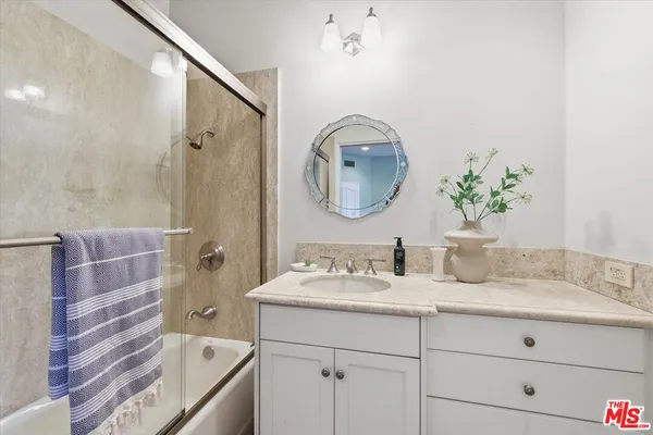 a bathroom with a tub sink and mirror