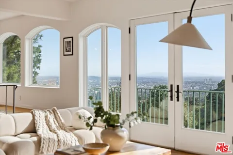 a living room with furniture and a floor to ceiling window