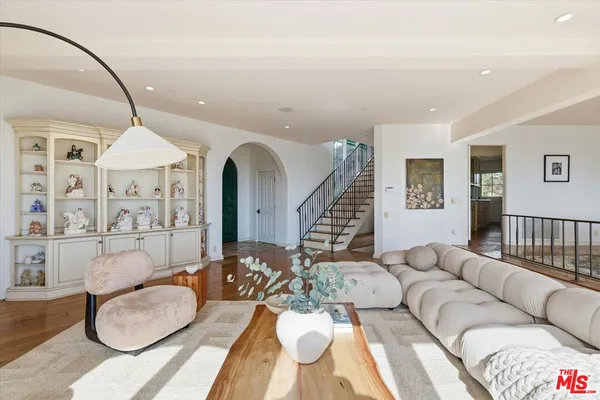 a living room with furniture a rug and white walls