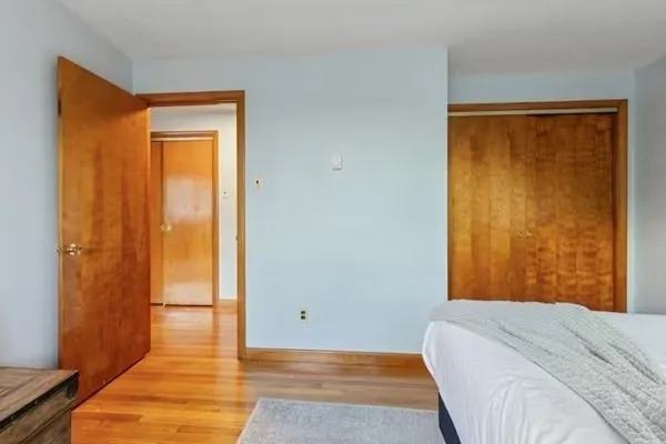 a bedroom with a bed and wooden floor