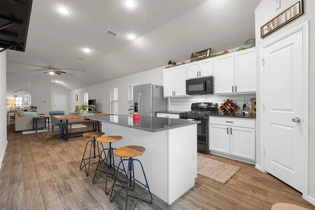 a kitchen with stainless steel appliances granite countertop a sink stove and cabinets