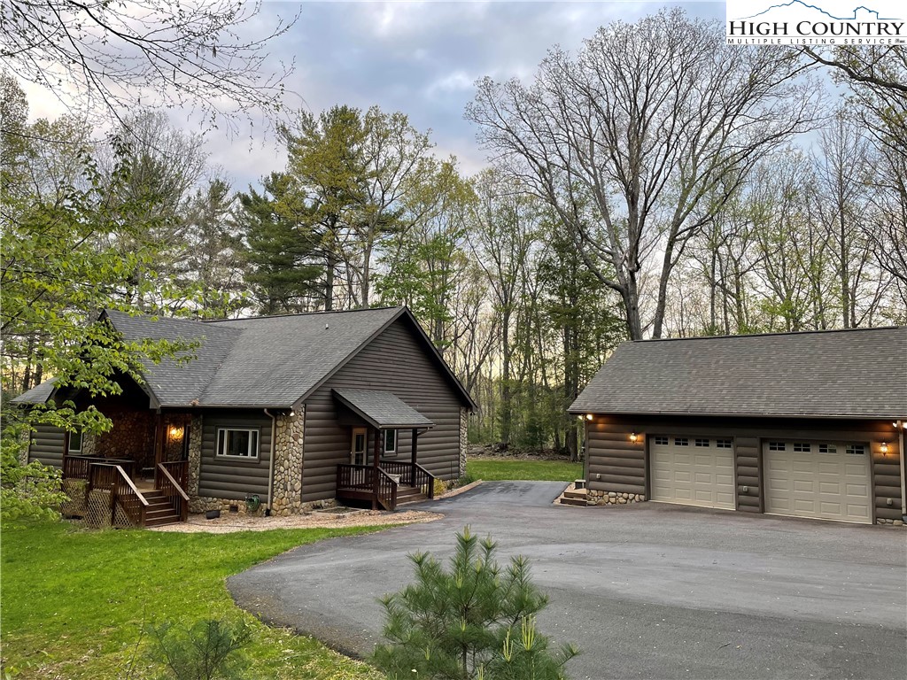 541 Woodland Ridge Lansing, NC 28643 - Photo 3 of 45 a front view of a house with a garden and trees