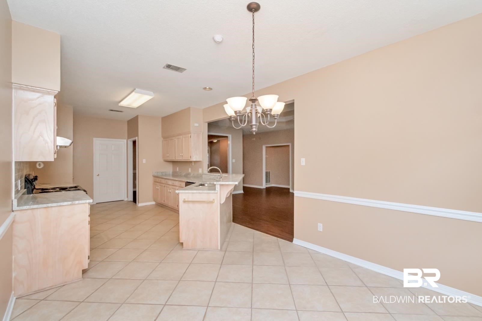 6117 Lennox Place Mobile, AL 36693 - Photo 22 of 39 Kitchen with electric range, a notable chandelier, light countertops, a kitchen breakfast bar, and a peninsula