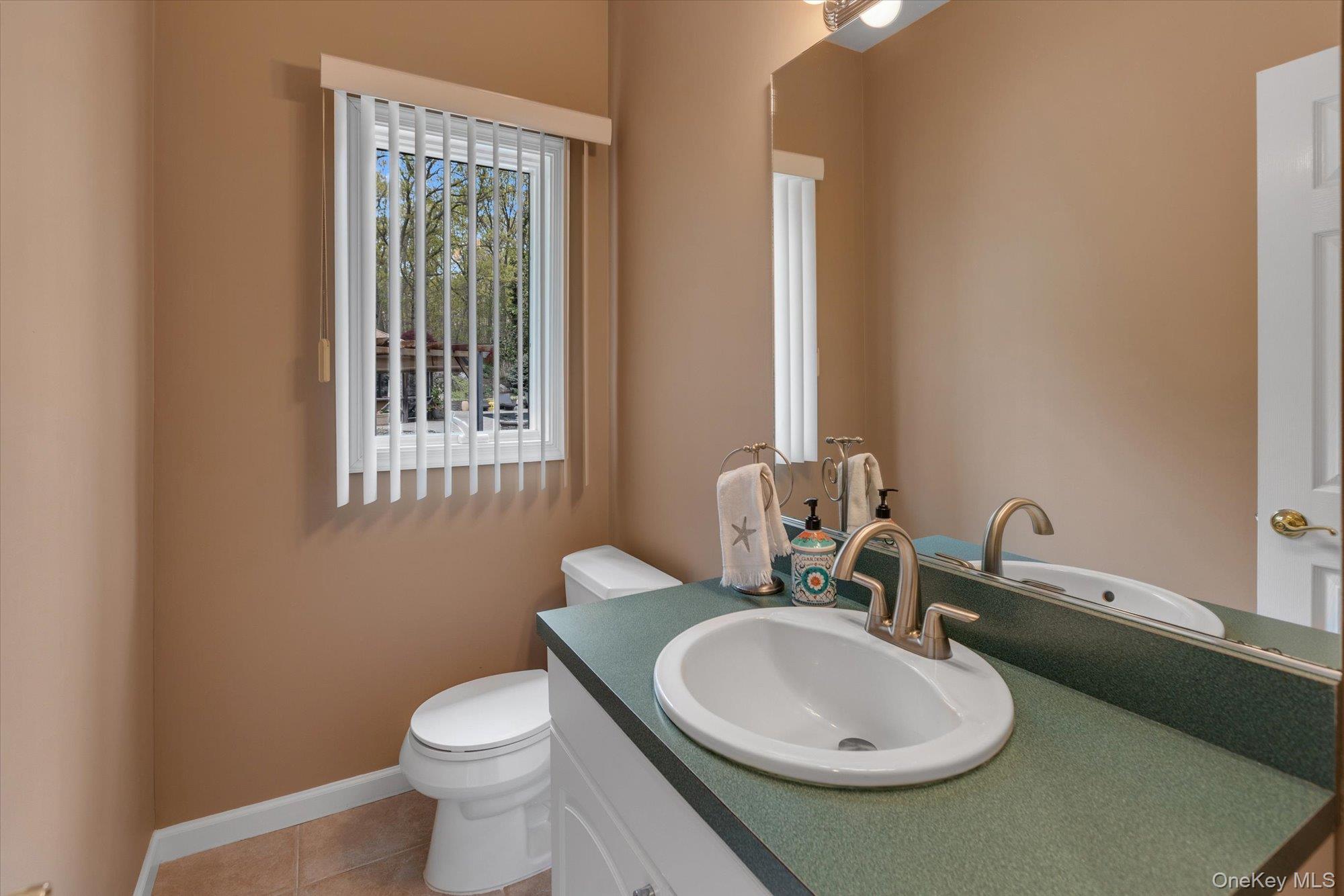 263 Old Commack Road Kings Park, NY 11754 - Photo 14 of 42 a bathroom with a toilet sink and mirror