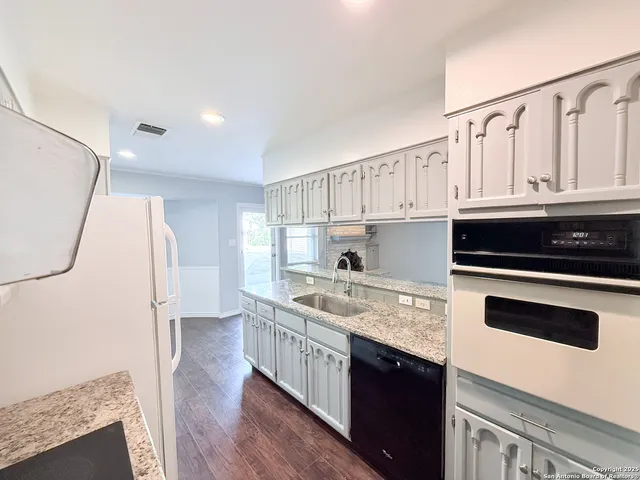 a kitchen with stainless steel appliances granite countertop a stove a sink and a refrigerator