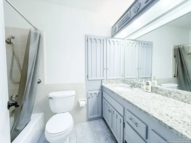 a bathroom with a granite countertop sink toilet and shower