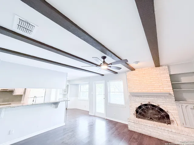 a cat sitting on a floor in a kitchen next to a window