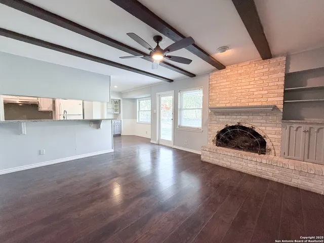 a view of a livingroom with a fireplace wooden floor and window