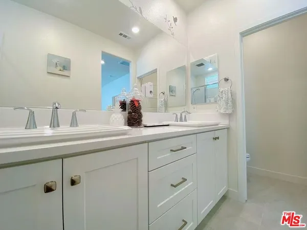 a bathroom with a double vanity sink and mirror
