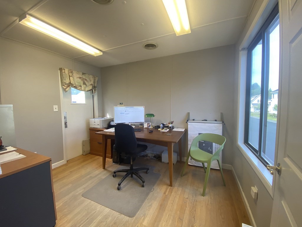 a view of a workspace with furniture and a window