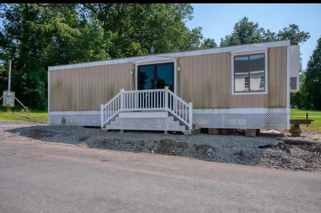 a view of a house with a yard and sitting area