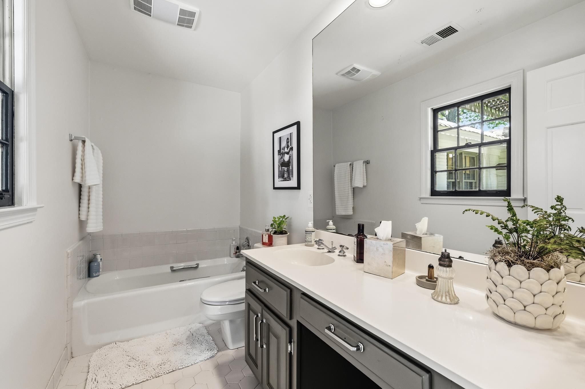 253 Ridgefield Road Memphis, TN 38111 - Photo 21 of 32 Bathroom featuring a white bathtub, toilet, and a dual-sink vanity with a light-colored countertop