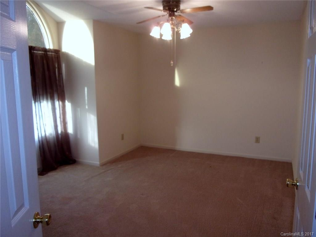 36074 Finger Road, Unit 2 Mount Pleasant, NC 28124 - Photo 7 of 21 an empty room with a chandelier fan and windows
