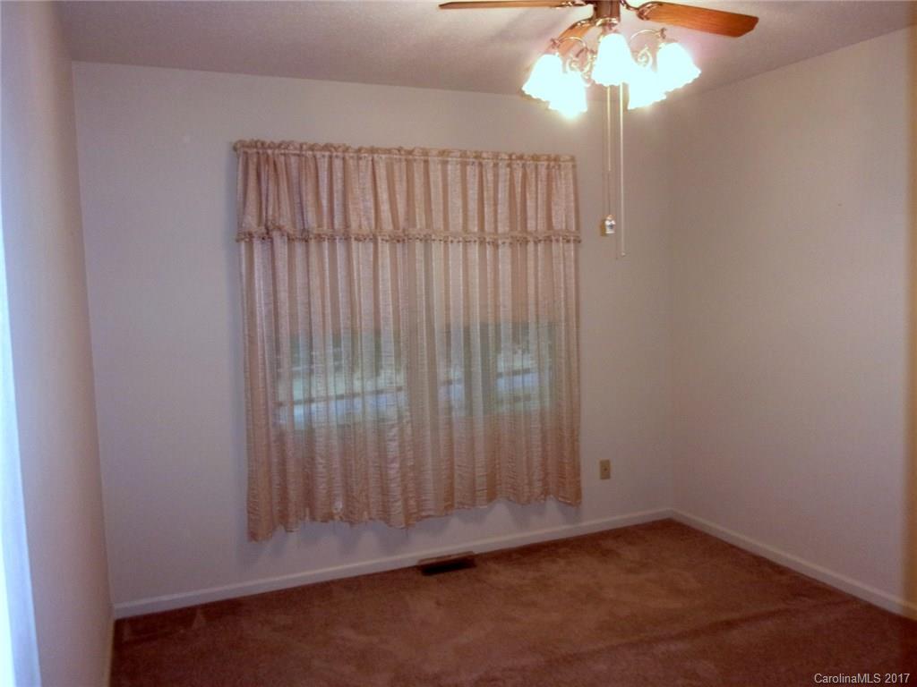 36074 Finger Road, Unit 2 Mount Pleasant, NC 28124 - Photo 8 of 21 an empty room with wooden floor and chandelier fan