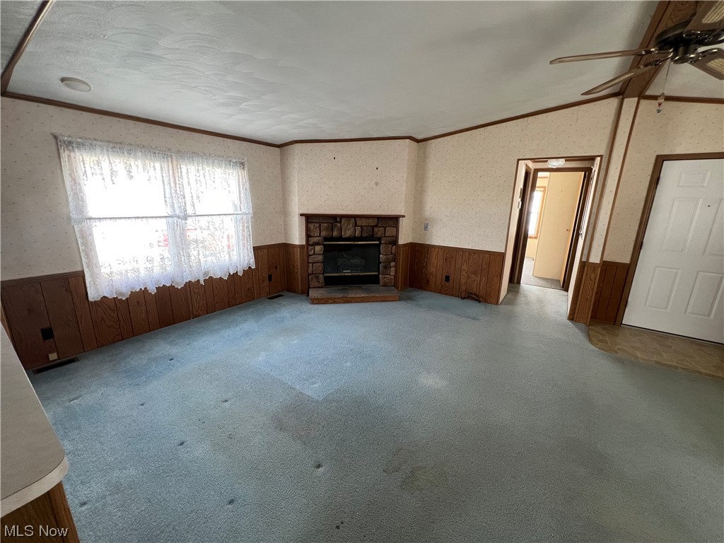 12921 Springfield Road, Unit 3N New Springfield, OH 44443 - Photo 6 of 19 Unfurnished living room with a fireplace, light carpet, crown molding, and ceiling fan