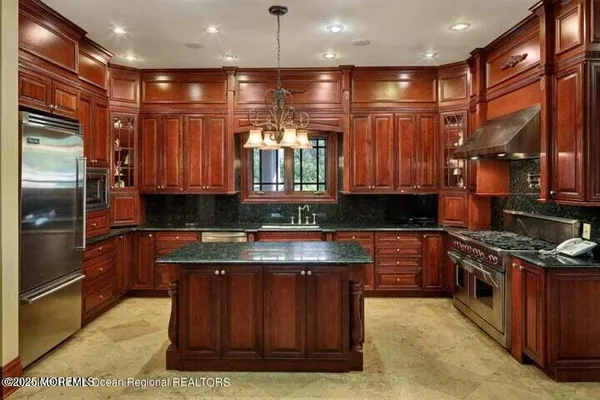 a kitchen with stainless steel appliances granite countertop a stove a sink and a refrigerator