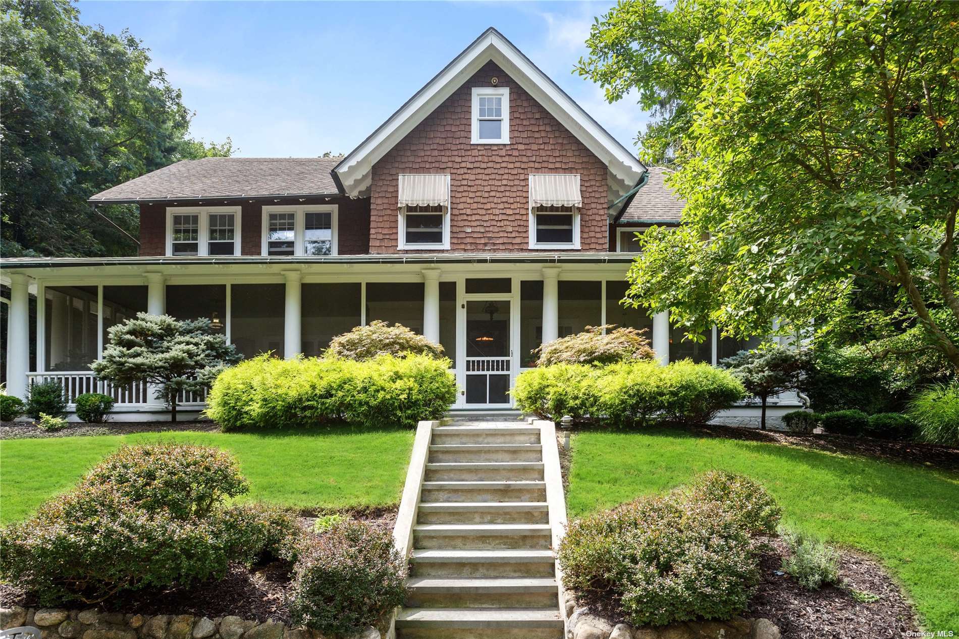 a front view of a house with a yard and potted plants