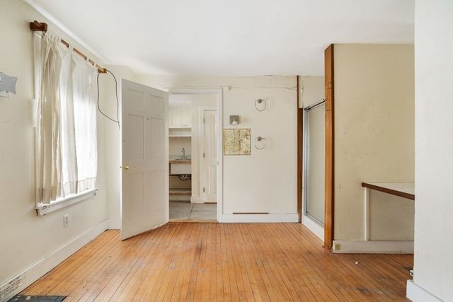 an empty room with wooden floor and a window