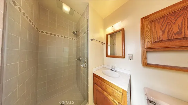 a bathroom with a granite countertop sink a mirror and shower