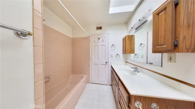 a bathroom with a tub sink and mirror